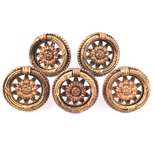 Five large ornately-decorated vintage brass ring pulls with sunflower designs in the middle