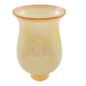 A tall, bell-shaped glass lamp shade standing upright on its fitter. It is a warm yellowish off-white color, and the rim has been painted a warm brown with a second stripe of brown just below. The glass contains many bubbles, most of which have been stretched during the blowing process, creating visual texture.