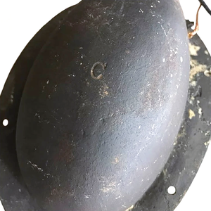 A close-up of the back of an antique iron wall sconce, showing some surface wear and the letter "C" stamped into the back