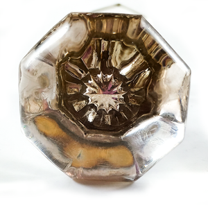 A front view of one of the knobs on a white background, showing the twelve-pointed silver mercury glass "star" in the middle