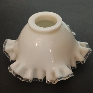 Side view of a ruffled milk glass lamp shade with clear glass along the edges, photographed on a dark grey background. The fitter is unusually thick.