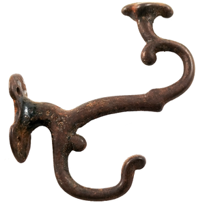 A uniquely-shaped antique iron double coat hook facing to the right, with an odd crest shape on top of the upper hook