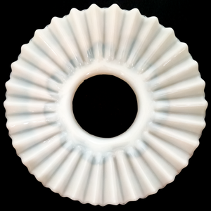 The underside of a white ruffled petticoat shade made of opalescent glass on a black background