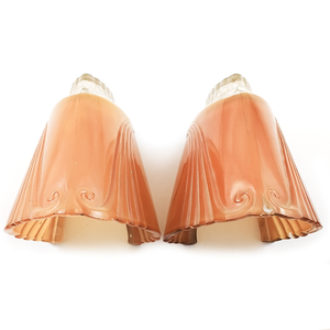 Twp orange glass Art Deco slip shades, with partly scalloped edges, swirling decorative patterns, and clear portions partly visible