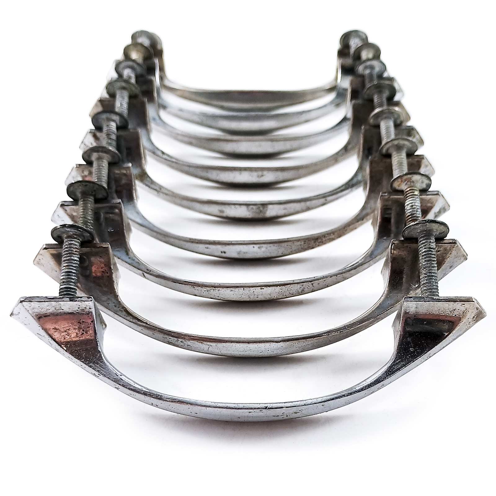 Nine nickel-plated vintage drawer handles with mounting screws lined up in a row