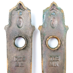 A close-up of the back of the escutcheons, showing the stamps more clearly