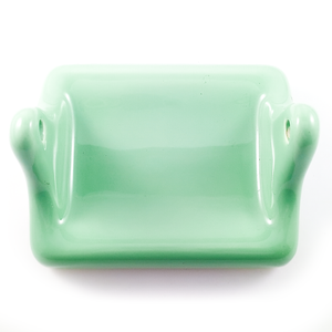 The toilet paper roll holder - a rounded rectangular base with two "arms" jutting out to hold the paper. The interior of the base is slightly curved to accommodate a round roll.