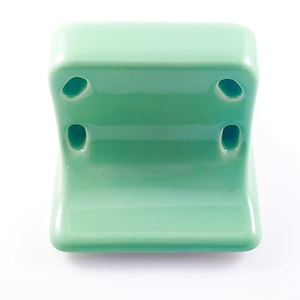 The underside of the toothbrush holder, which is mostly smooth glazed porcelain, interrupted only by the four toothbrush holes
