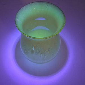 The rim under UV light, highlighting the bubble texture and showing the way the glass under the painted rim fluoresces where the paint is thin