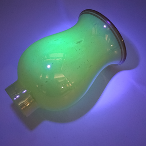 An angled view of the shade on its side, still under UV light, showcasing more of the bubble texture