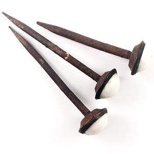 Three rusted iron nails with screw threads on the top, holding on ceramic domed heads