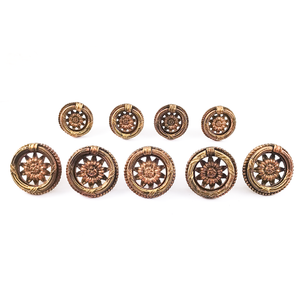 Five large and four small vintage brass ring pulls, all with sunflowers in the middle, arranged in two rows