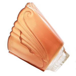 An orange glass Art Deco slip shade with a clear portion near the base and scrolling designs along the sides. It has a large crack in one side, and is missing a small bit of its orange coating in one spot.