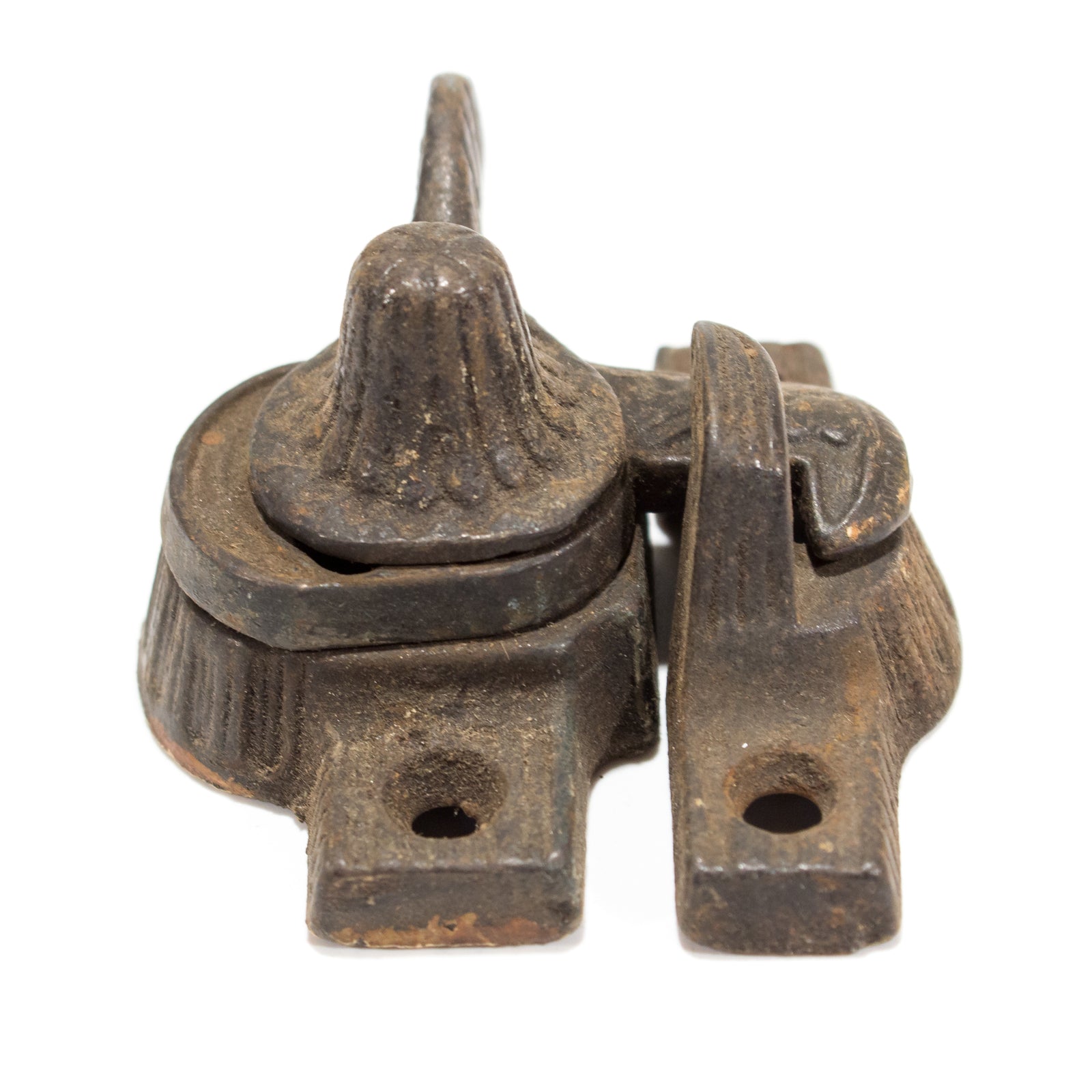 A close-up of a Victorian window latch with a floral design on the thumb turn