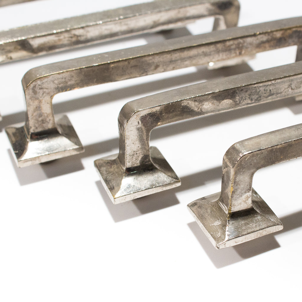 this picture shows the ends of three vintage silver colored drawer pulls