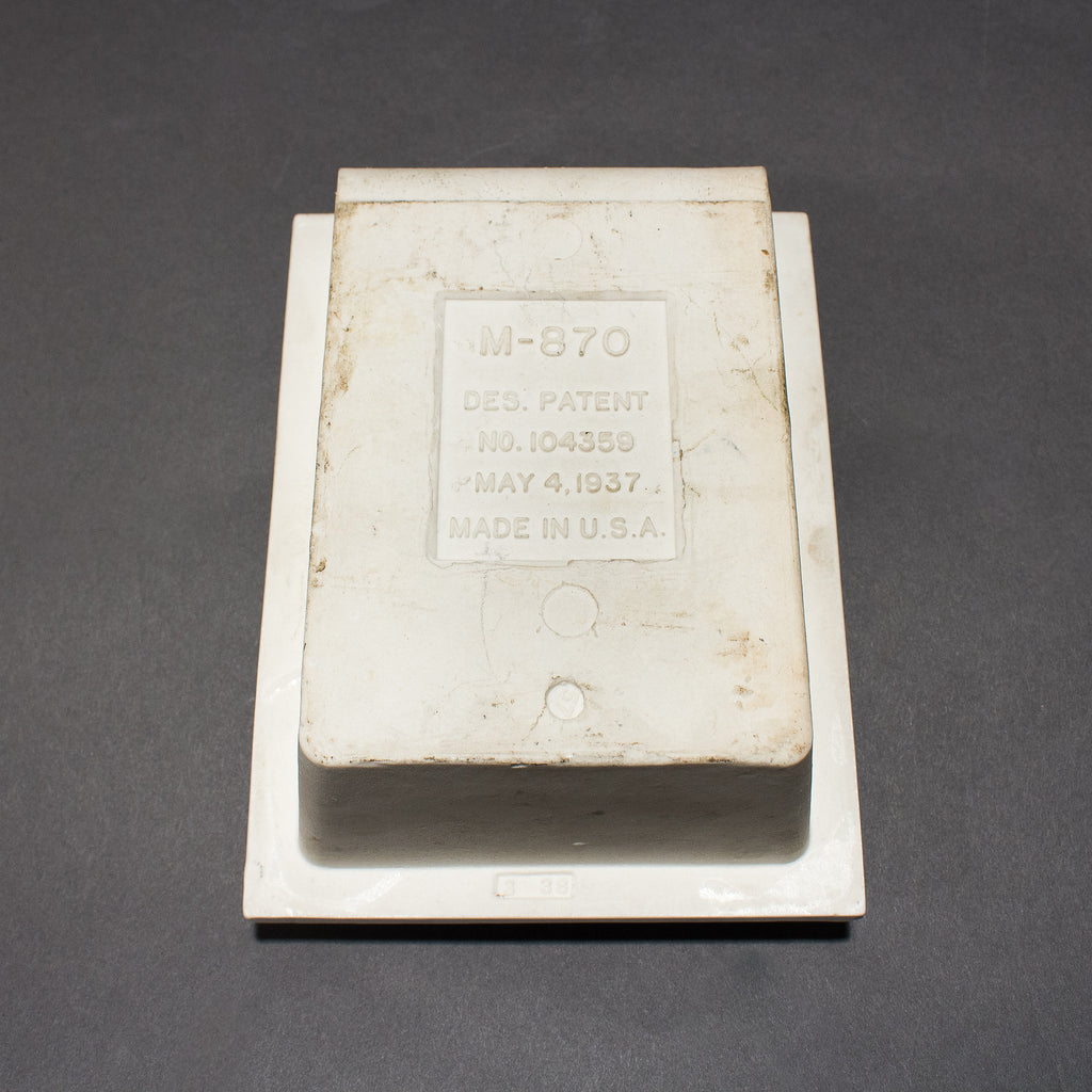 this is a picture of the back of a vintage white porcelain soap insert with the words M-870 Des. Patent No. 104359 May 4, 1937 Made in the USA