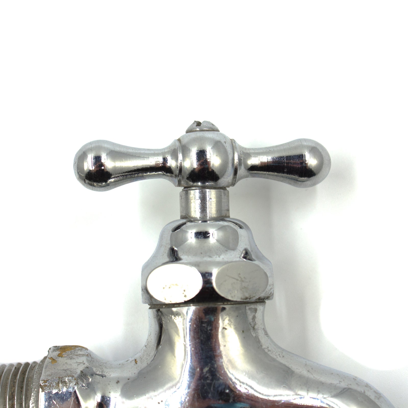 Two chrome-plated faucet taps, one of which has some scratching from a wrench used to unscrew it