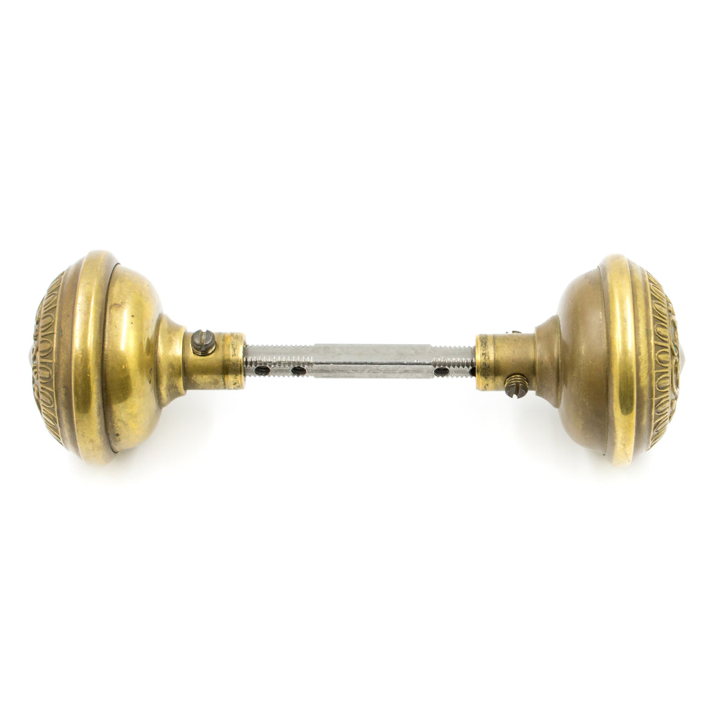 this is a profile picture of a brass door knob set showing both knobs and the spindle between them