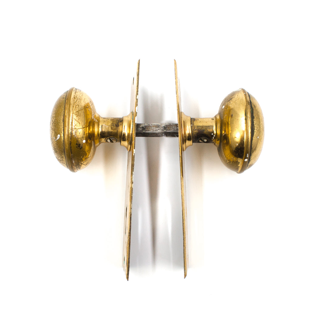 this is a side profile view of a vintage bronze door knob set