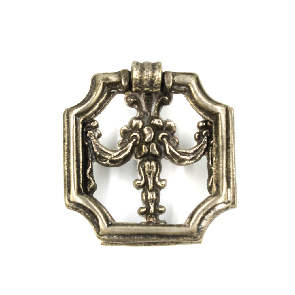 this is an antique vintage silver colored square shaped ring pull with a floral design in the center