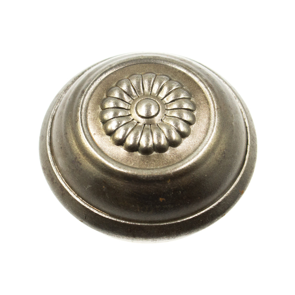 this is a close up view of an antique victorian knob. there is a flower design in the center
