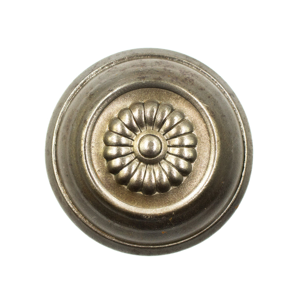 this is a bird's eye or straight on view of a victorian door knob with a flower design in the center