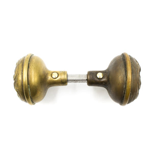 this is a profile view of an antique brass art nouveau door knob set and this picture shows the spindle between them