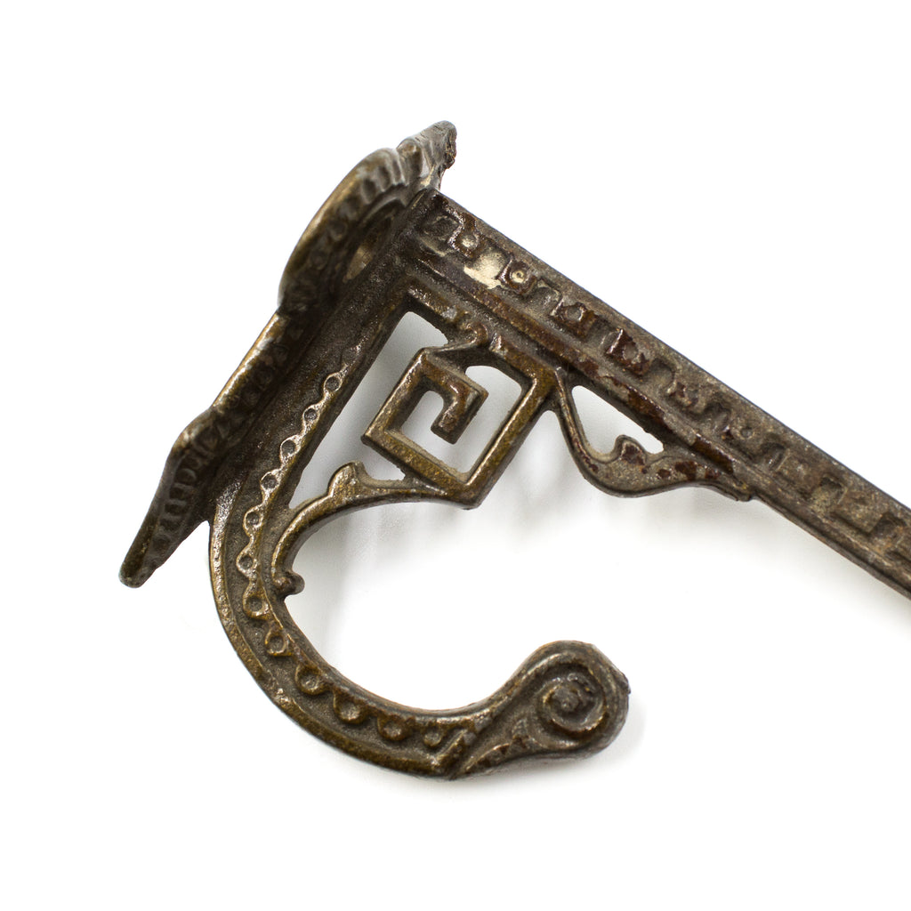 this is a picture of the corner and detail on an antique victorian double hook and it shows a small piece of dirt 