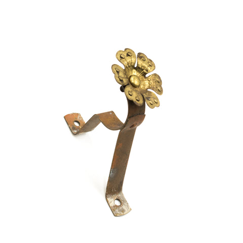 this is a vintage brass curtain rod bracket with a large flower design