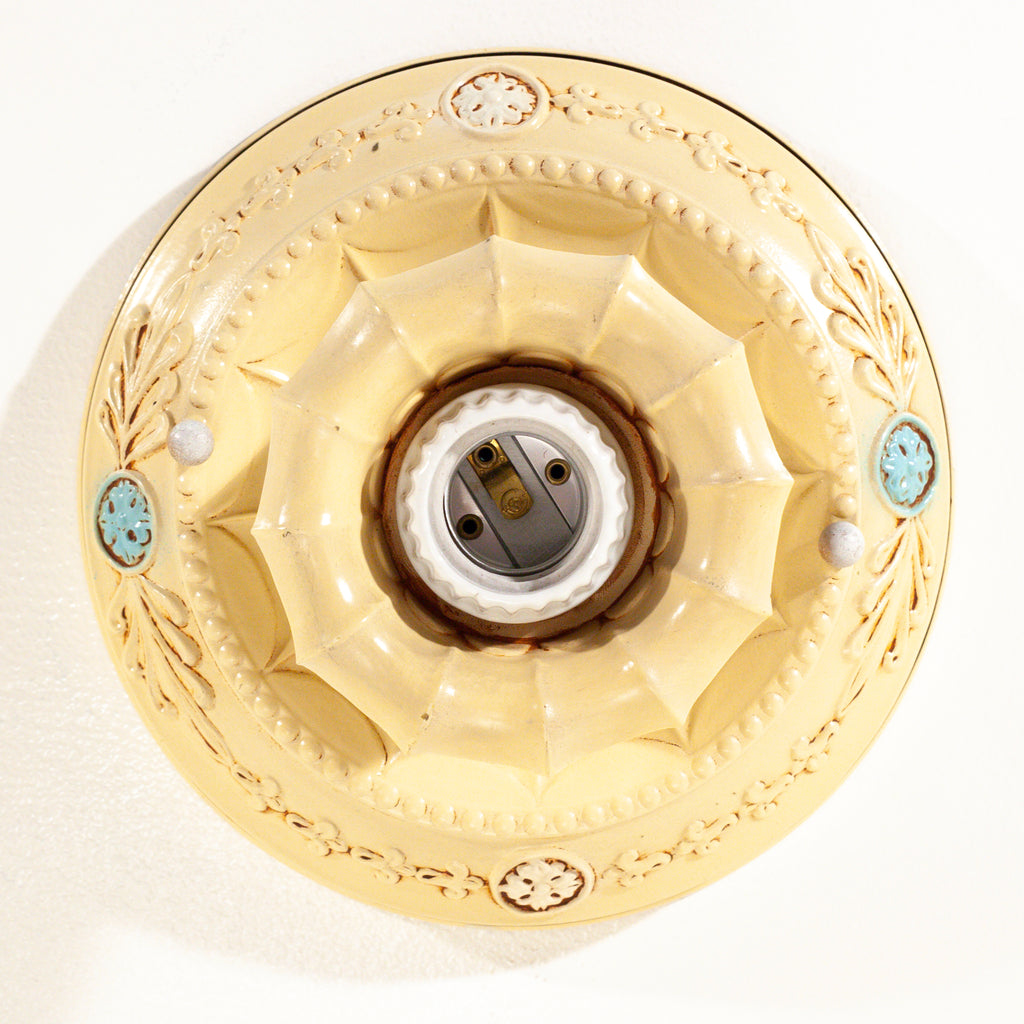 this picture shows a bird's eye view of the bottom of the canopy on a vintage bare bulb ceiling fixture 