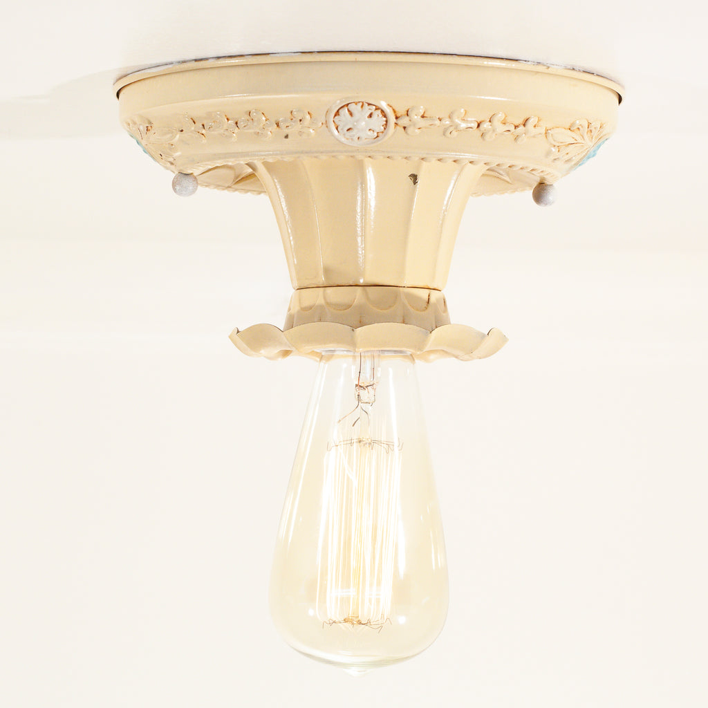 this is a vintage bare bulb ceiling fixture with a floral design 