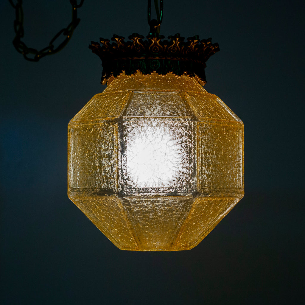 this picture shows a vintage yellow glass crackle shade swag light lit up with a darker background