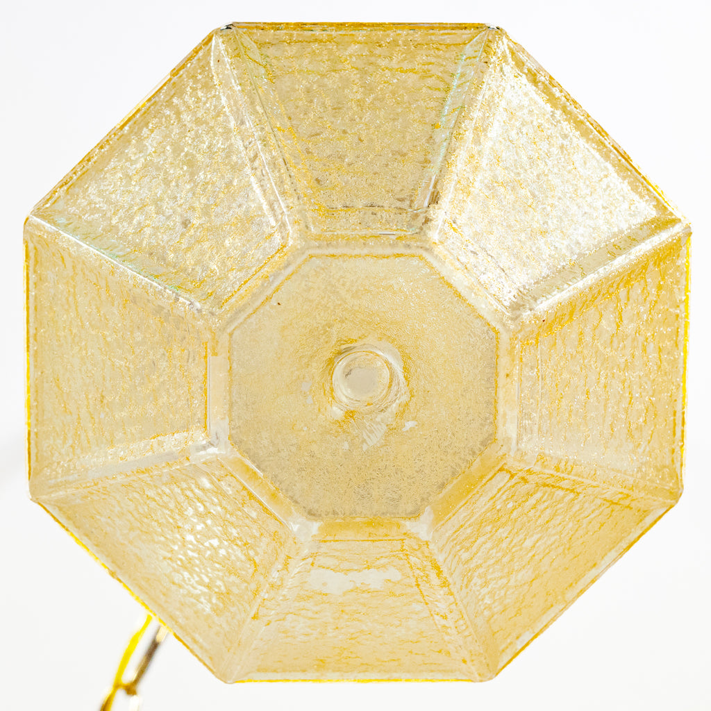 this picture shows the bottom of a vintage yellow glass crackle shade swag light. The shade is not lit. 