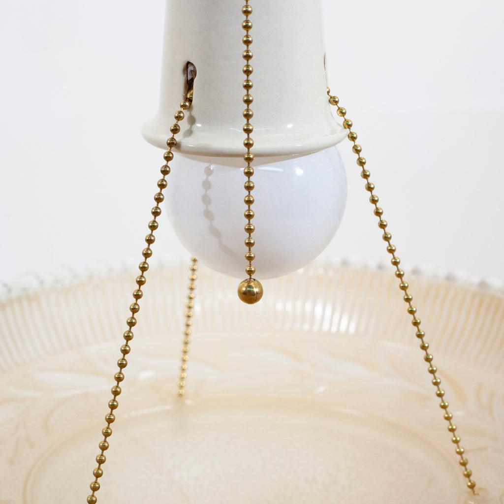 this is the pull chain for a vintage mid century three chain light fixture with a lightbulb