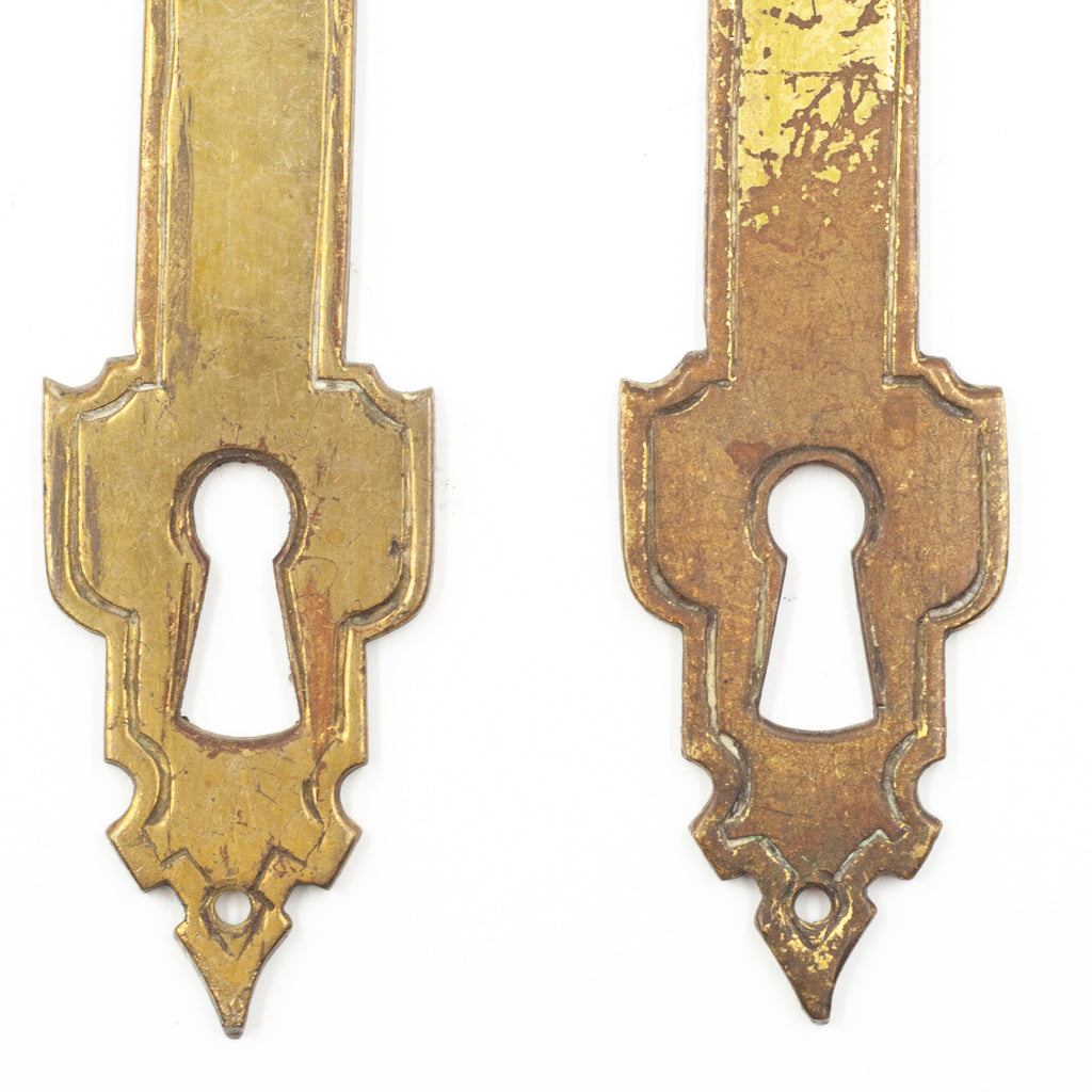 this is an up close picture of the ends of a pair of vintage brass escutcheons showing the difference in wear on each of them and also where the keyhole is