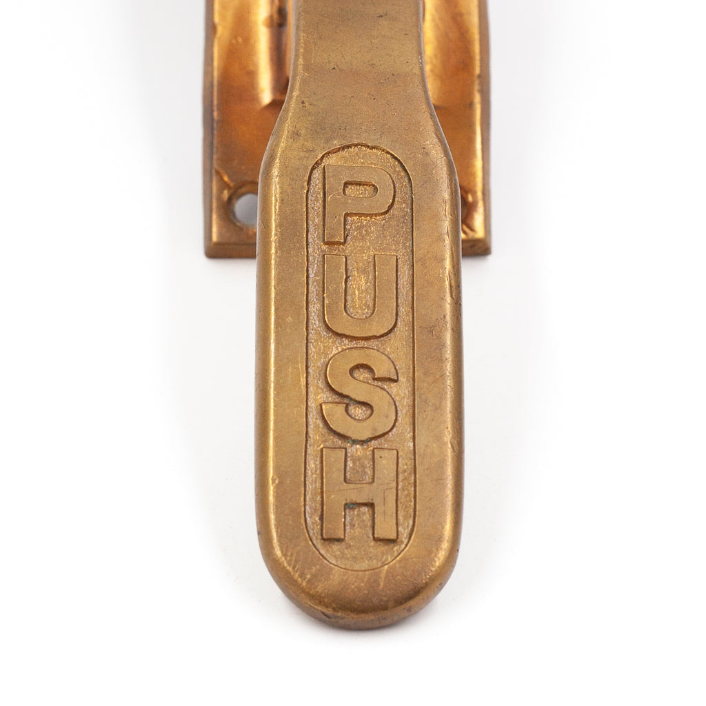 this is a close up picture of the words "push" on a vintage brass exit paddle. There is a little wear on the surface. 
