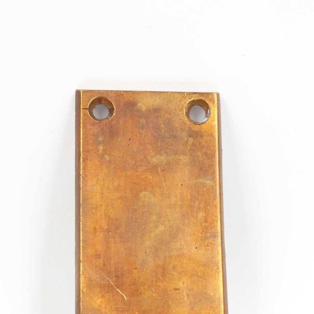 this picture shows the top part of a vintage brass exit paddle, it shows the screw holes on the top and a little wear and patina on the surfaces
